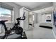 Bright bedroom features a peloton bike and sliding barn door to an ensuite bathroom at 4790 E Dartmouth Ave, Denver, CO 80222