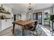 Dining area with modern chandelier, wood table, and doors to the backyard at 4790 E Dartmouth Ave, Denver, CO 80222