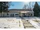 Inviting front exterior with a walkway, covered porch, and snow covered lawn at 4790 E Dartmouth Ave, Denver, CO 80222