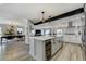 Modern kitchen featuring a large island with seating, a wine fridge, and open access to the dining area at 4790 E Dartmouth Ave, Denver, CO 80222
