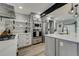 Bright kitchen with stainless steel appliances, white cabinetry, and a view of the island and dining area at 4790 E Dartmouth Ave, Denver, CO 80222