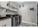Functional laundry room with washer, dryer, and built-in shelving at 4790 E Dartmouth Ave, Denver, CO 80222