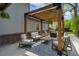 Inviting outdoor patio with comfortable seating, wooden pergola, and stylish blue patterned rug at 4790 E Dartmouth Ave, Denver, CO 80222