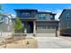 Attractive two-story home boasts a two-car garage and a welcoming front porch with stone accents at 10976 Snowdon St, Parker, CO 80134