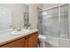 Bathroom with glass shower, oak cabinet vanity, and framed mirror at 12702 E 105Th Ave, Commerce City, CO 80022