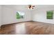 Spacious primary bedroom with a ceiling fan and dual windows with backyard views at 12702 E 105Th Ave, Commerce City, CO 80022
