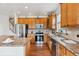 Well-equipped kitchen with stainless steel appliances, wood cabinets, and a breakfast bar at 12702 E 105Th Ave, Commerce City, CO 80022