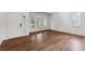Bright living room with multiple windows, a white front door, and wood laminate flooring at 12702 E 105Th Ave, Commerce City, CO 80022