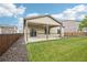 Spacious backyard features a covered patio, lush lawn, and well-maintained fence at 2328 Saddle Back Ct, Fort Lupton, CO 80621