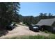 Exterior view of a home with a long, dirt driveway, a black sedan, and an SUV at 28127 Knowles Rd # Ab&C, Evergreen, CO 80439