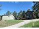 Exterior view of a house with a paved driveway and surrounding trees on a sunny day at 28127 Knowles Rd # Ab&C, Evergreen, CO 80439