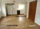 Living room with wood-look flooring opening up to the kitchen at 28127 Knowles Rd # Ab&C, Evergreen, CO 80439