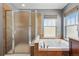 Bathroom featuring a soaking tub, separate shower, and tiled surround for a spa-like experience at 2521 N Xenia St, Denver, CO 80238