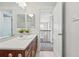 Bright bathroom features a single sink vanity and mirrors and leads to an open landing at 2521 N Xenia St, Denver, CO 80238
