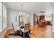 Open dining area with hardwood floors, a modern chandelier, and a glass table, adjacent to the well-equipped kitchen at 2521 N Xenia St, Denver, CO 80238