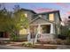 Charming two-story home featuring a welcoming front porch and landscaped yard at dusk at 2521 N Xenia St, Denver, CO 80238