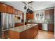 Spacious kitchen with stainless steel appliances, dark wood cabinets, an island with counterspace, and hardwood floors at 2521 N Xenia St, Denver, CO 80238