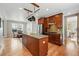 Open kitchen with stainless steel refrigerator, dark wood cabinets, island with counter space, and hardwood floors at 2521 N Xenia St, Denver, CO 80238