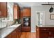 Kitchen featuring a sink, built-in oven, and dark wood cabinets, complemented by hardwood floors and modern fixtures at 2521 N Xenia St, Denver, CO 80238