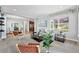 Inviting living room with carpet, large windows, stylish furniture, and an open layout leading to the dining area and kitchen at 2521 N Xenia St, Denver, CO 80238