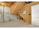 Unfinished basement area, showing exposed beams, water tank, and doorway to a finished section at 2775 S Jebel Way, Aurora, CO 80013