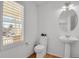 Half bathroom featuring a pedestal sink, toilet, and window with exterior view at 2775 S Jebel Way, Aurora, CO 80013