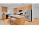 Modern kitchen featuring wood cabinets, stainless steel appliances, and a center island with bar seating at 2775 S Jebel Way, Aurora, CO 80013