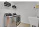 Modern laundry room with stainless steel washer and dryer, plus a utility sink at 2775 S Jebel Way, Aurora, CO 80013