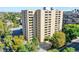 An exterior view of a high-rise building with private balconies surrounded by mature trees and city views at 800 N Pearl St # 303, Denver, CO 80203