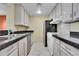 Galley kitchen featuring stainless steel appliances, white cabinets, and dark countertops at 800 N Pearl St # 303, Denver, CO 80203