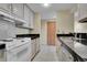 Galley kitchen featuring stainless steel appliances, white cabinets, and dark countertops at 800 N Pearl St # 303, Denver, CO 80203