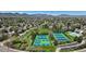 Aerial view of tennis courts in a green residential neighborhood with a mountain backdrop, perfect for active living at 9867 W Berry Dr, Littleton, CO 80123