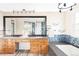 Bathroom with double sink vanity, granite counters, blue tile backsplash, and large mirror at 9867 W Berry Dr, Littleton, CO 80123