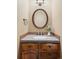 Bathroom vanity featuring granite counters, tile backsplash, a vessel sink and an oval mirror at 9867 W Berry Dr, Littleton, CO 80123