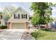 Charming two-story home with a well-manicured lawn, brick accents, and an attached two-car garage at 9867 W Berry Dr, Littleton, CO 80123