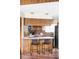 Eat-in kitchen features wood cabinets, stone countertops, bar seating, and modern appliances at 9867 W Berry Dr, Littleton, CO 80123
