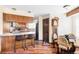 Eat-in kitchen features wood cabinets, stone countertops, bar seating, and a charming grandfather clock at 9867 W Berry Dr, Littleton, CO 80123