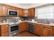 Open kitchen features stainless steel appliances, granite countertops, tile backsplash, and ample cabinet space at 9867 W Berry Dr, Littleton, CO 80123