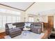 Comfortable living room with hardwood floors, a sectional sofa, and large windows at 9867 W Berry Dr, Littleton, CO 80123