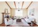 Bright living room with hardwood floors, fireplace, wood beams, and ample seating at 9867 W Berry Dr, Littleton, CO 80123