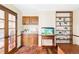 Comfortable office with custom built-ins, shelving, wet bar, hardwood floors, and natural light at 9867 W Berry Dr, Littleton, CO 80123