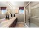 Bathroom featuring double sinks, long countertop, and glass enclosed shower and tub at 15844 E Lake Cir, Centennial, CO 80016