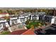 Aerial view of modern townhomes surrounding a grassy park with playground and mature trees at 2900 W Parkside Pl, Denver, CO 80221