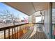 Balcony with wood flooring, view of the street, and wooden railing at 17118 E Whitaker Dr # E, Aurora, CO 80015
