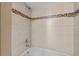 Shower with a decorative tile inset and built in corner shelves at 17118 E Whitaker Dr # E, Aurora, CO 80015