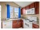 Bright kitchen features a white range, granite countertops, and wood cabinetry at 17118 E Whitaker Dr # E, Aurora, CO 80015