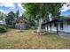 Spacious backyard with a covered patio and mature trees creating a private outdoor retreat at 5041 S Julian St, Englewood, CO 80110