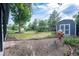 Large backyard area with mature tree and storage shed provides a serene outdoor space at 5041 S Julian St, Englewood, CO 80110