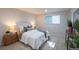 Cozy bedroom features soft lighting, neutral decor, plush bedding, and window, offering a warm and relaxing space at 5041 S Julian St, Englewood, CO 80110