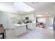 Updated kitchen with skylight, white cabinets, island, and stainless appliances seamlessly connects to a cozy living space at 5041 S Julian St, Englewood, CO 80110